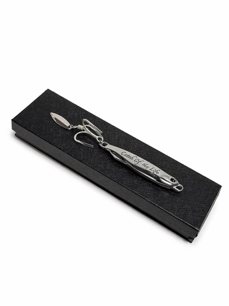 Black box with custom engraved lure on top on a white background