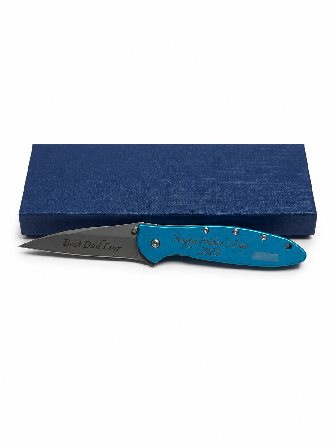 A folding pocket knife with a bright blue handle and a dark gray blade, displayed in front of a textured dark blue gift box on a white background. The blade is engraved with 'Best Dad Ever' and the handle is engraved with 'Happy Father's Day 2026'.