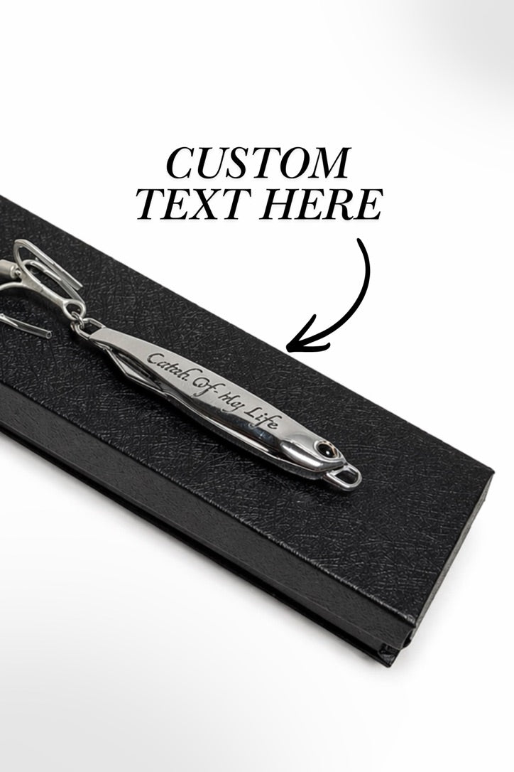 A silver metal keepsake pendant engraved with 'Crown Of My Life' resting on a black textured display box. Black text overlay reads 'CUSTOM TEXT HERE' with an arrow pointing to the engraving.