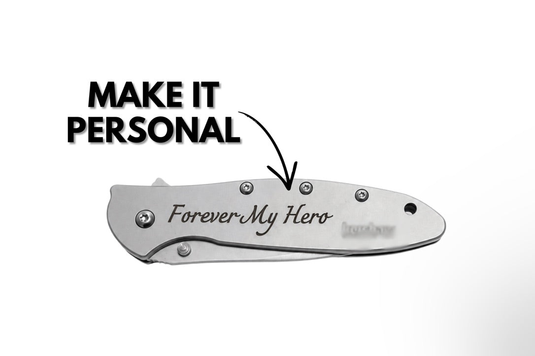 A silver folding pocket knife with 'Forever My Hero' engraved on the handle, shown on a white background with a black arrow and text reading 'MAKE IT PERSONAL'.