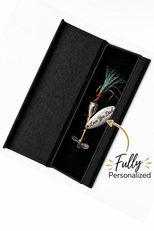 A silver metal fishing lure with a green and black skirt and a white tag reading 'Love Your Dad' inside an open black presentation box, on a white background with a 'Fully Personalized' graphic overlay.